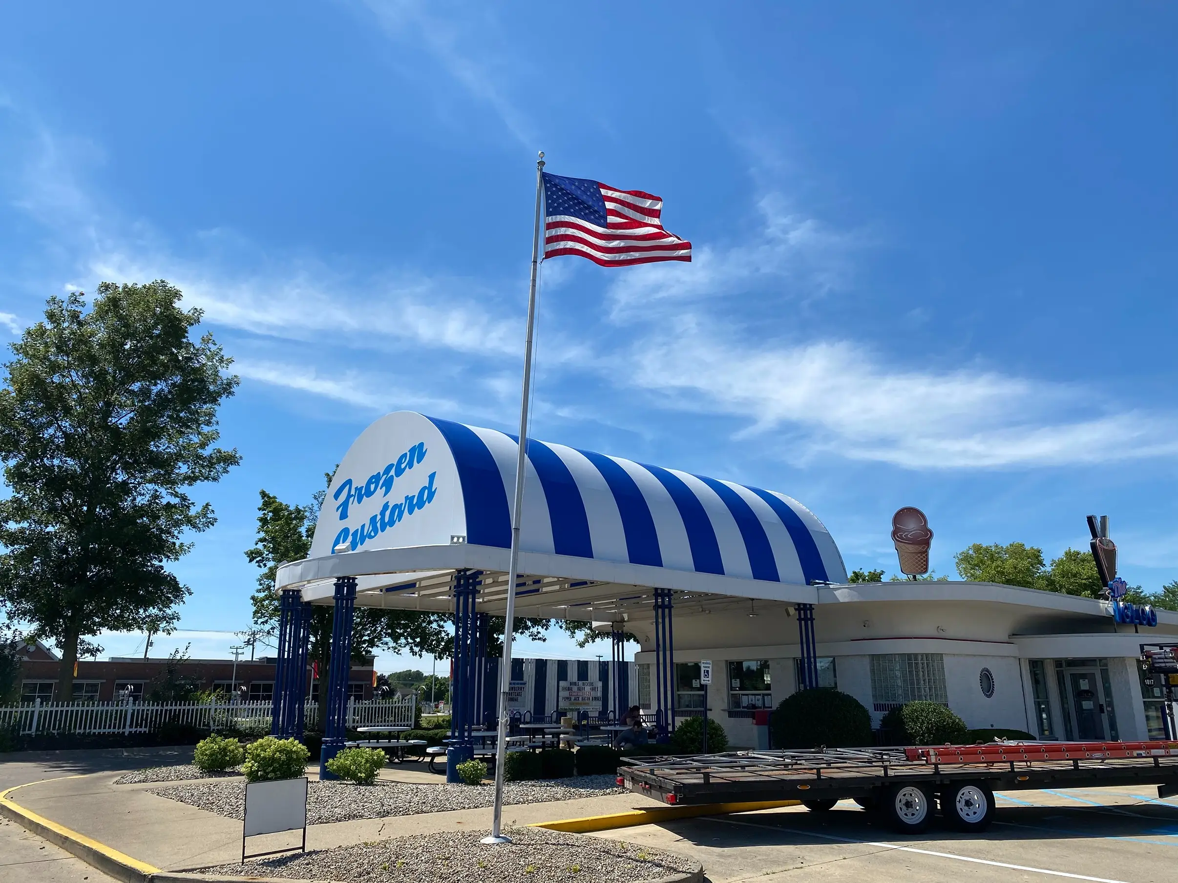 recover of awning; blue and white striped awning leading into shop